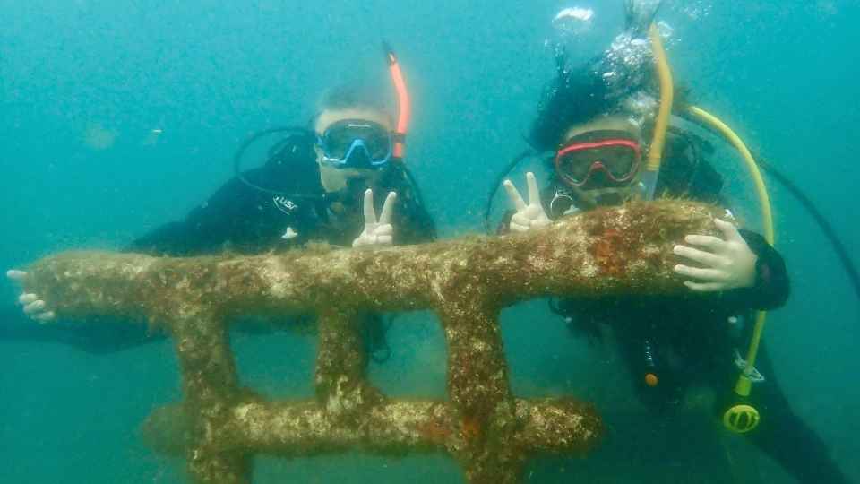 大瀬崎の水中オブジェ前で記念撮影する10歳のOWD講習生