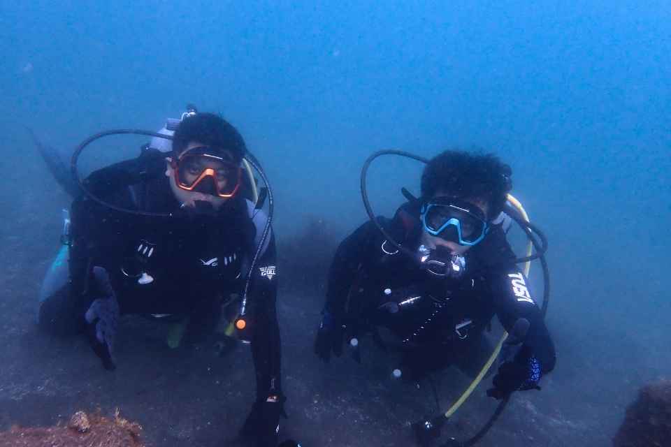 大瀬崎の水中で並んで記念撮影する2名のダイバー