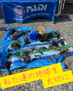 PADIクリーンナップイベントでダイバーが回収した海洋ゴミと「私たちの地球を大切に」のメッセージ