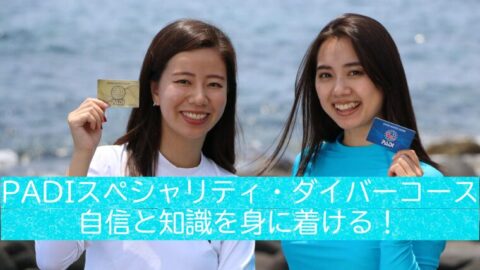 「PADIスペシャリティカードを手に持ち笑顔の女性2人｜ダイビングスキル向上を象徴するイメージ」