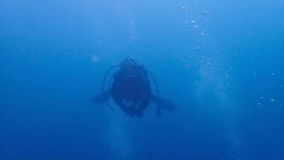 大瀬崎の青い水中を進むダイバーのシルエット